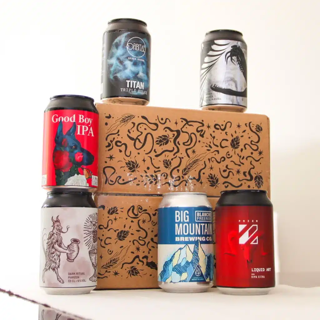 Canettes de bières artisanales devant les cartons de la box Une Petite Mousse