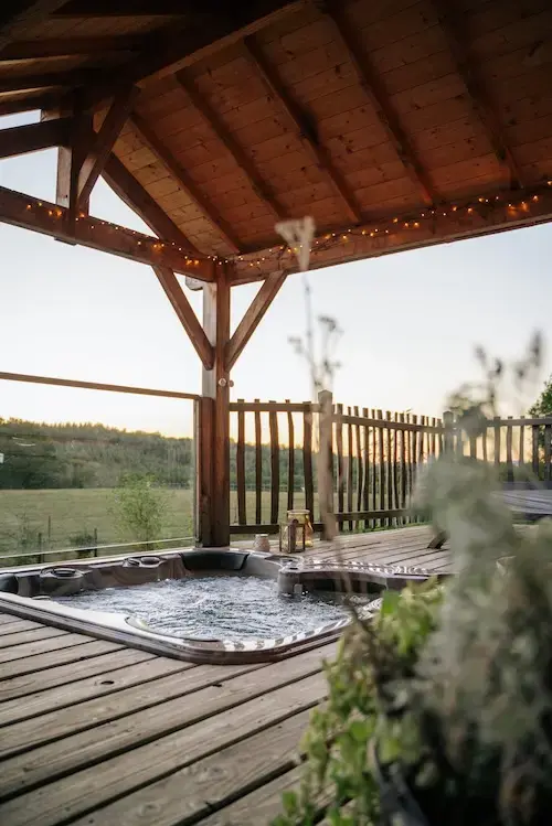 Jacuzzi sous pergola dans un hébergement nature